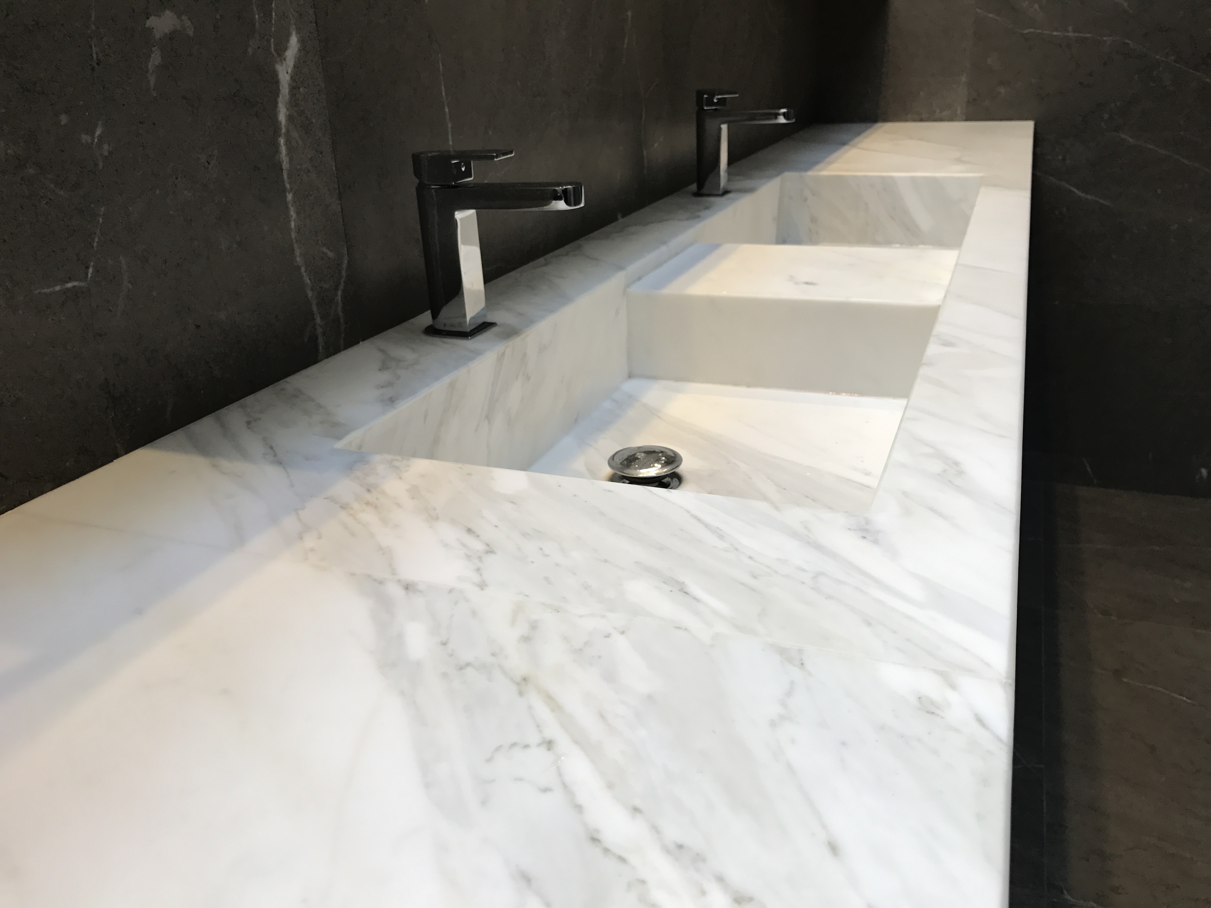 White marble double vanity with integrated basins and black taps