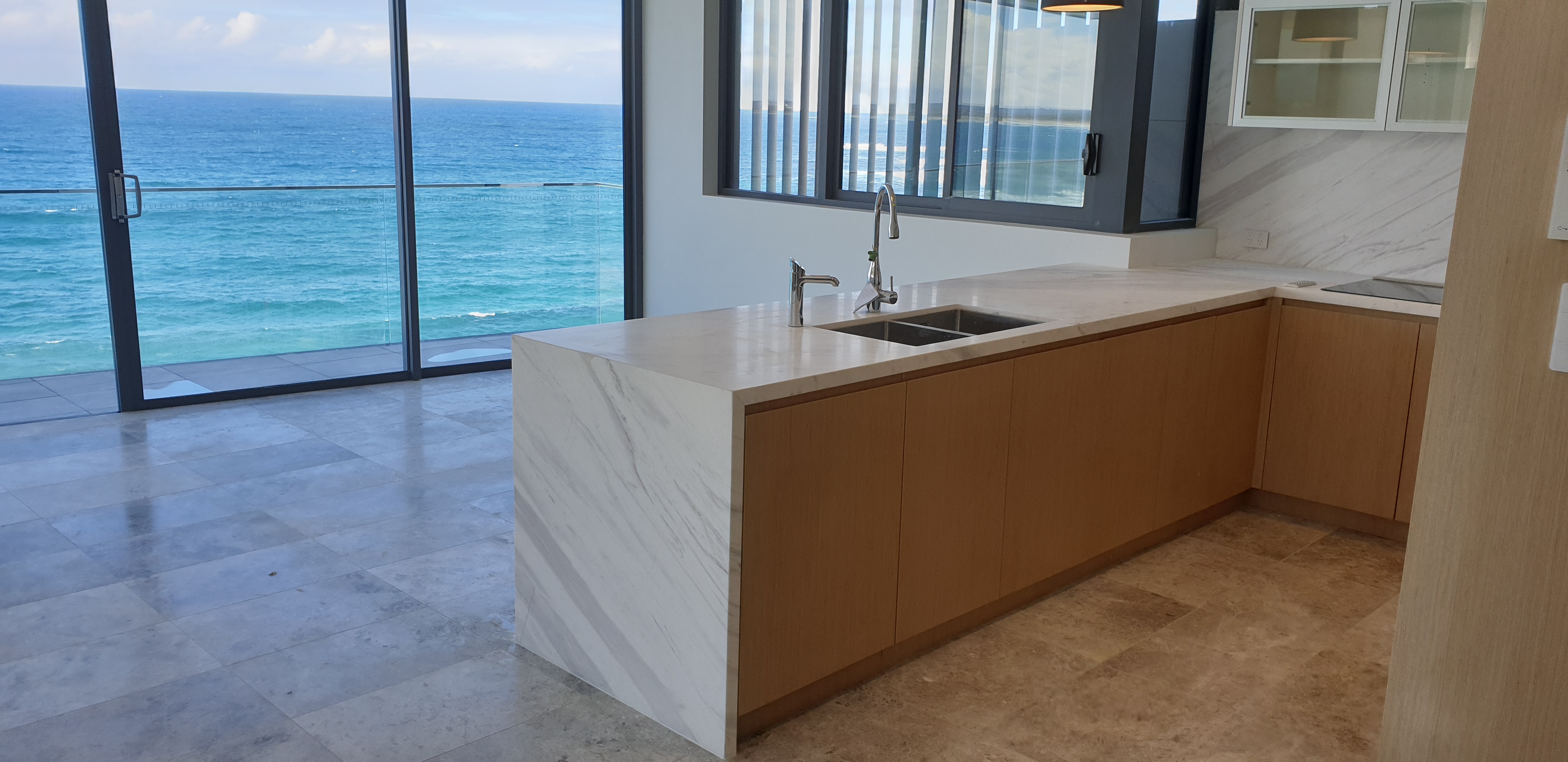 Oceanfront kitchen with a white stone waterfall island